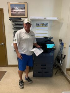 STAT Business Systems technician with Kyocera copier in Fort Lauderdale office, offering copier leasing in South Florida.