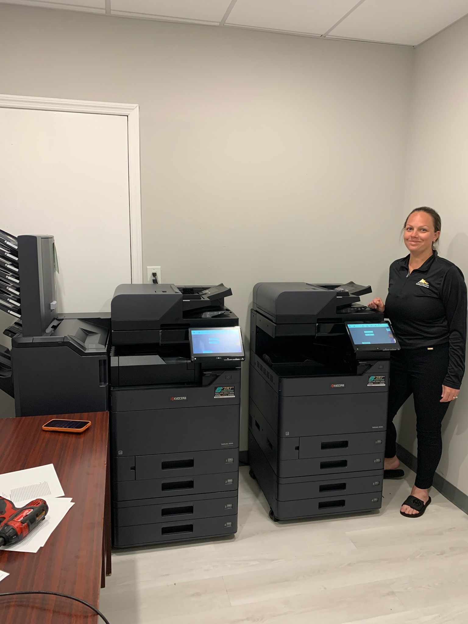Broward County title company office with two Kyocera multifunction copiers installed by STAT Business Systems, including a 7-bin mailbox finisher for organized document output and improved office workflow.