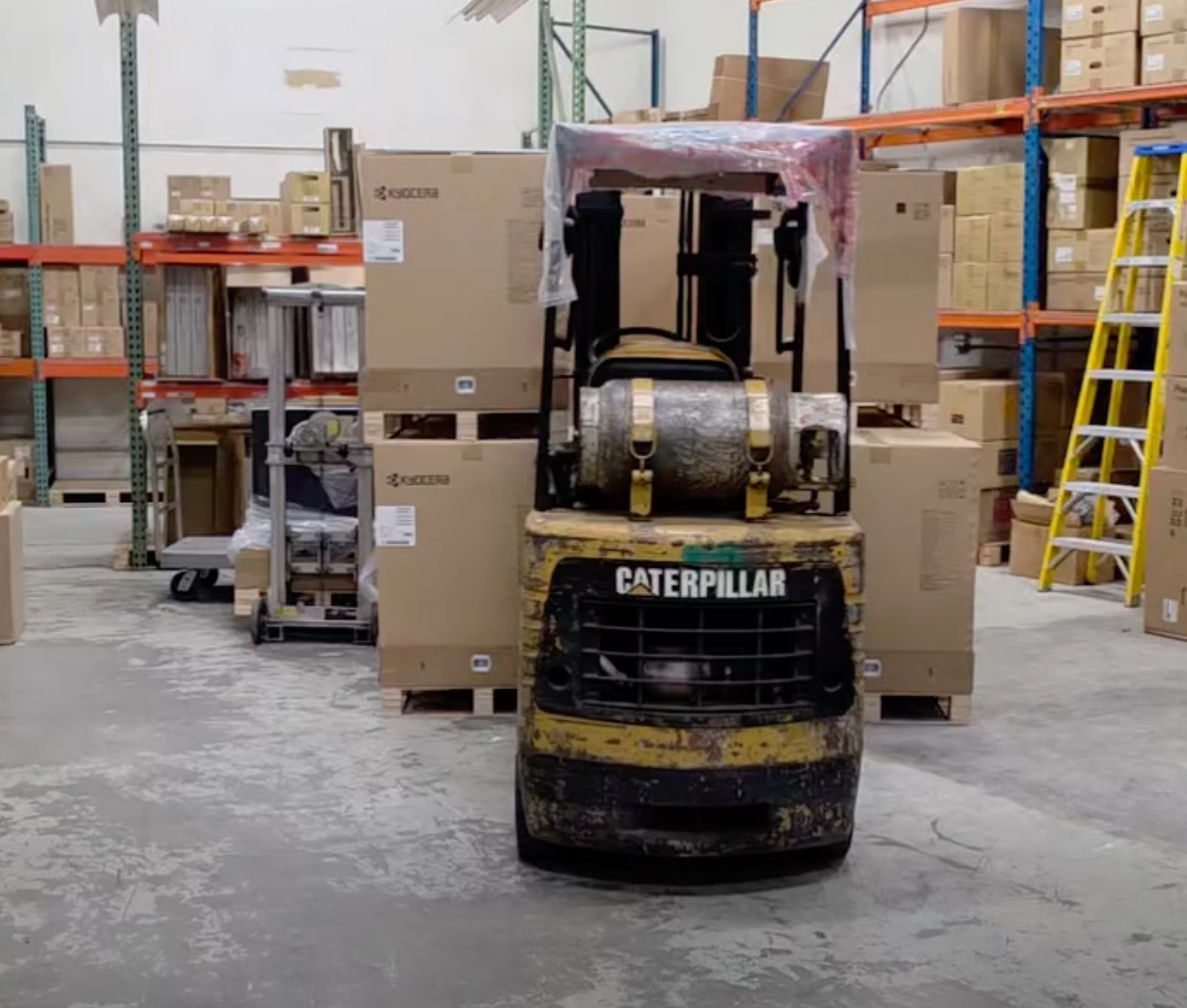 Forklift moving fresh Kyocera copier inventory inside the STAT Business Systems warehouse in Sunrise, Florida